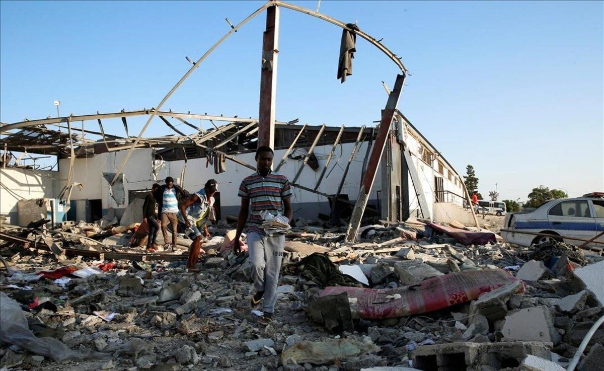 Inmigrantes recogen lo que queda de sus pertenencias tras el ataque aéreo sufrido en Trípoli. Inmigrantes recogen lo que queda de sus pertenencias tras el ataque aéreo sufrido en Trípoli.