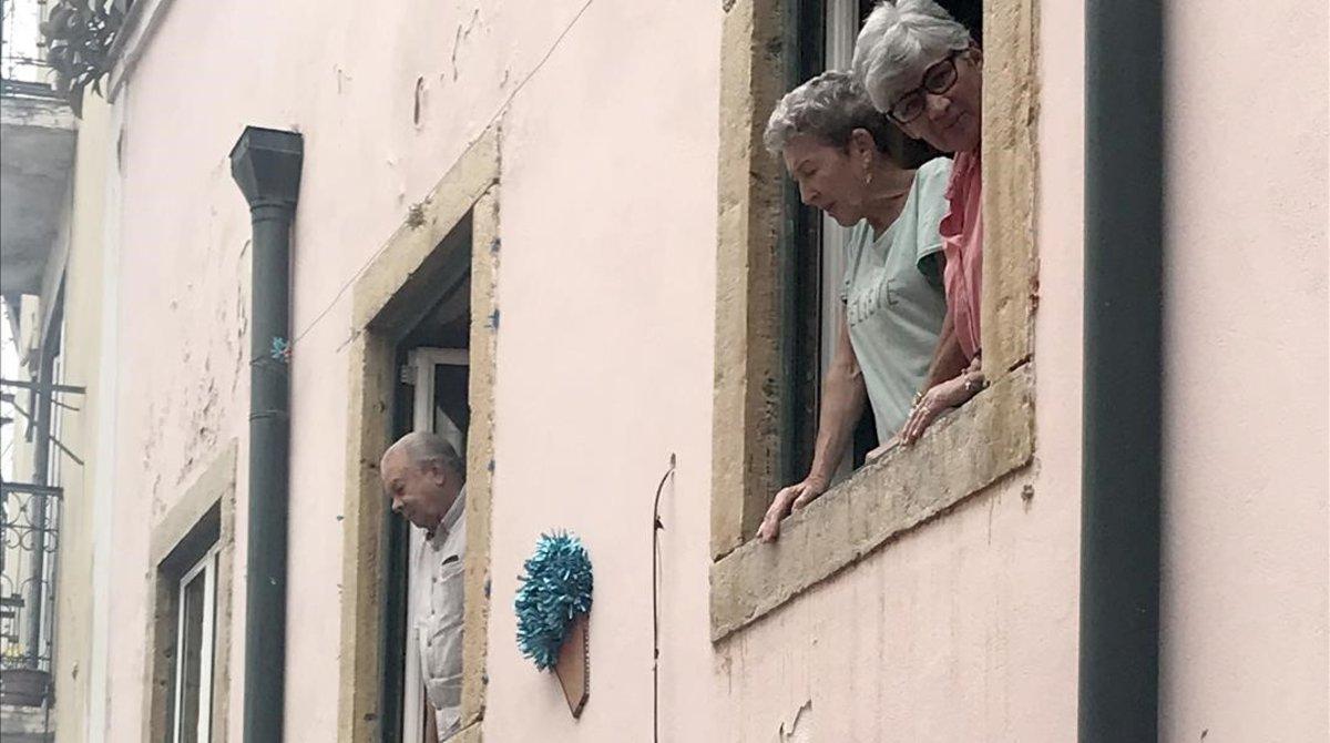 Turistas asomados a la ventanas en la Alfama.