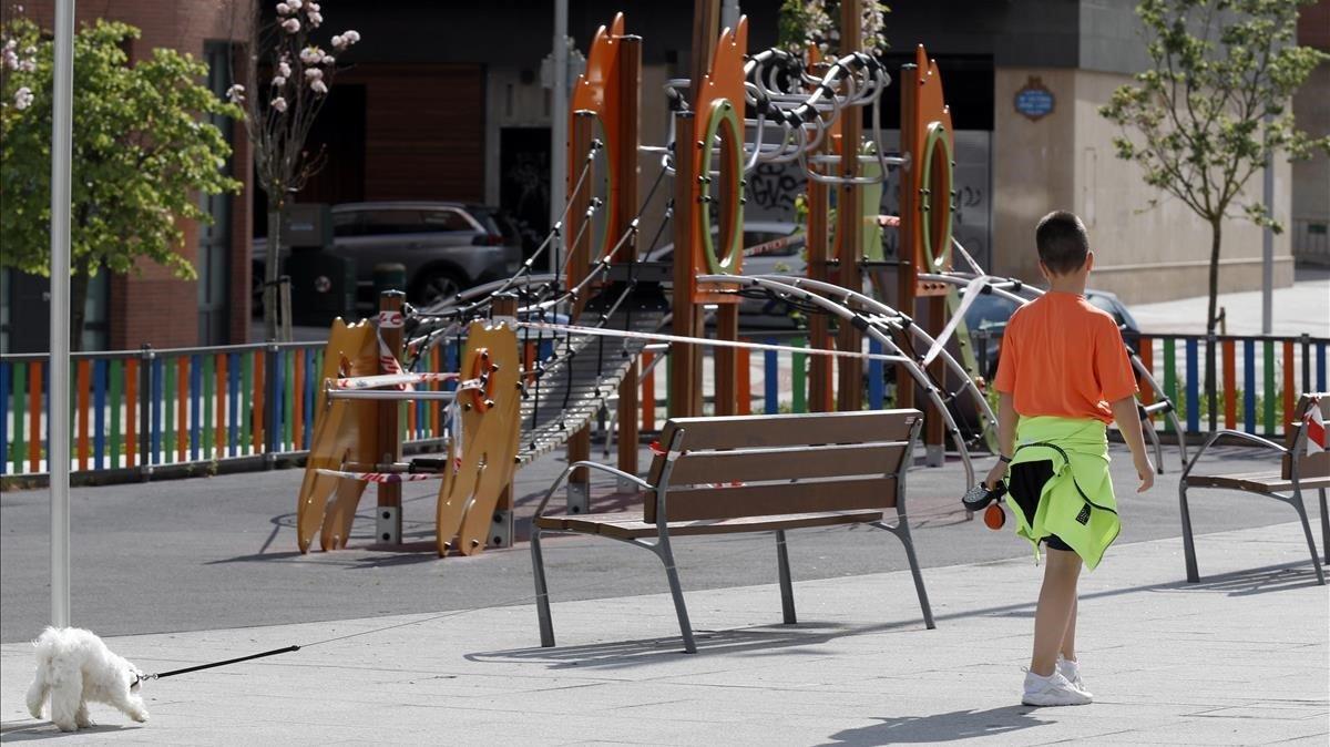 Un niño pasea a su perro en una calle de Bilbao durante el confinamiento decretado por la pandemia de covid-19 Un niño pasea a su perro en una calle de Bilbao durante el confinamiento decretado por la pandemia de covid-19
