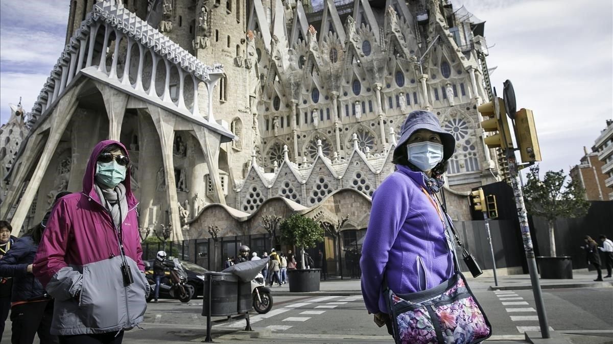 Turistas con mascarillas frente a la Sagrada Família, en Barcelona, este jueves. Turistas con mascarillas frente a la Sagrada Família, en Barcelona, este jueves.