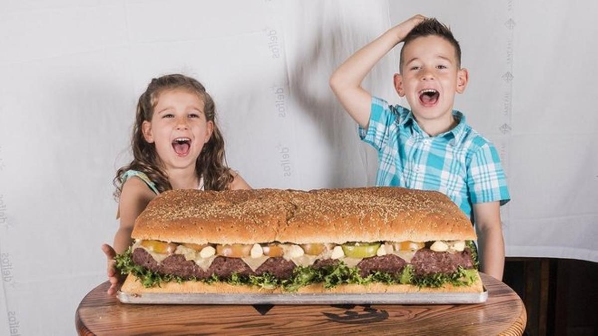 Dos niños posan con la hamburguesa de 17 kilos de La Kaña.