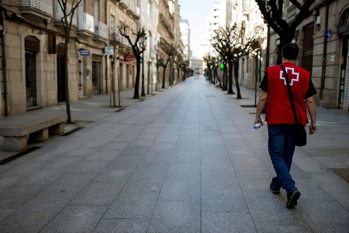 Un miembro de la Cruz Roja camina por una calle de Ourense (Galicia), vacía a causa del confinamiento por el coronavirus. Un miembro de la Cruz Roja camina por una calle de Ourense (Galicia), vacía a causa del confinamiento por el coronavirus.