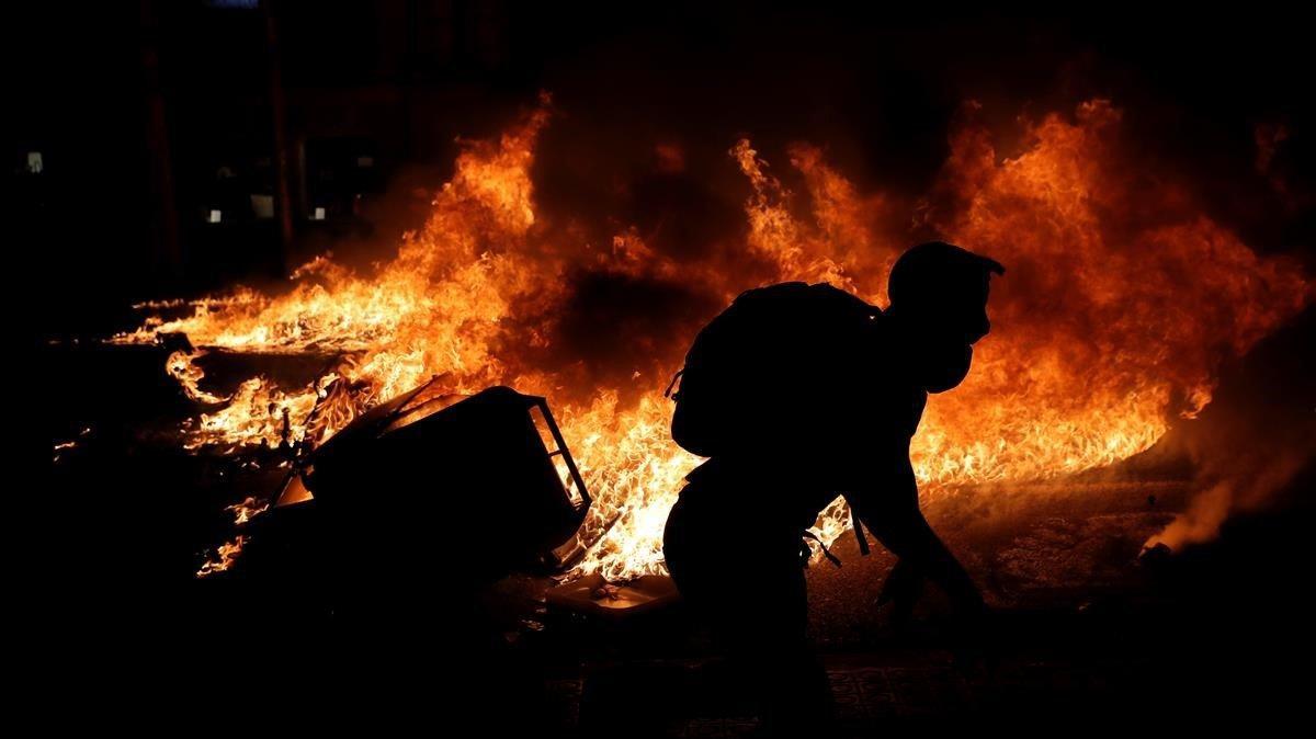 Un manifestante independentista junto a una barricada en llamas, la noche de este martes en el centro de Barcelona.