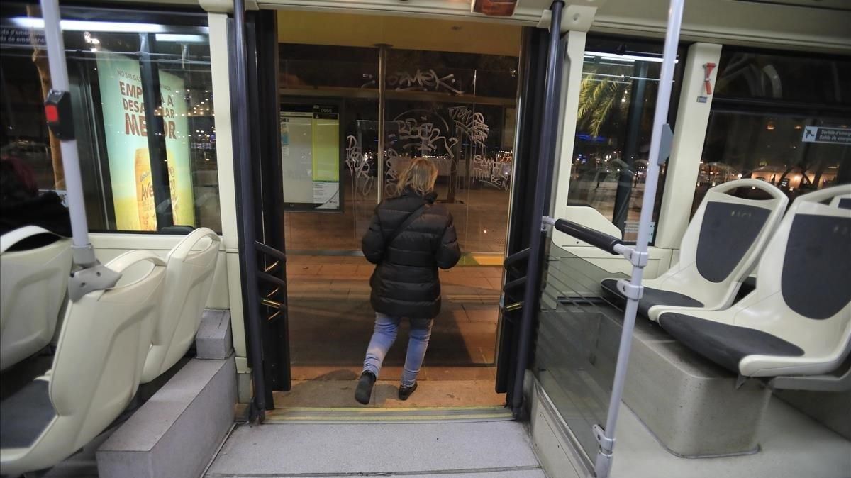 Una mujer baja de un autobús nocturno, en Barcelona. Una mujer baja de un autobús nocturno, en Barcelona.