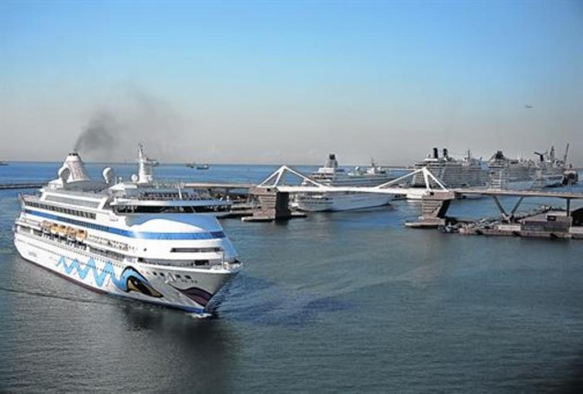 Un ferri humeante entra por la Bocana Nord junto al muelle Adossat, repleto de grandes cruceros. Un ferri humeante entra por la Bocana Nord junto al muelle Adossat, repleto de grandes cruceros.