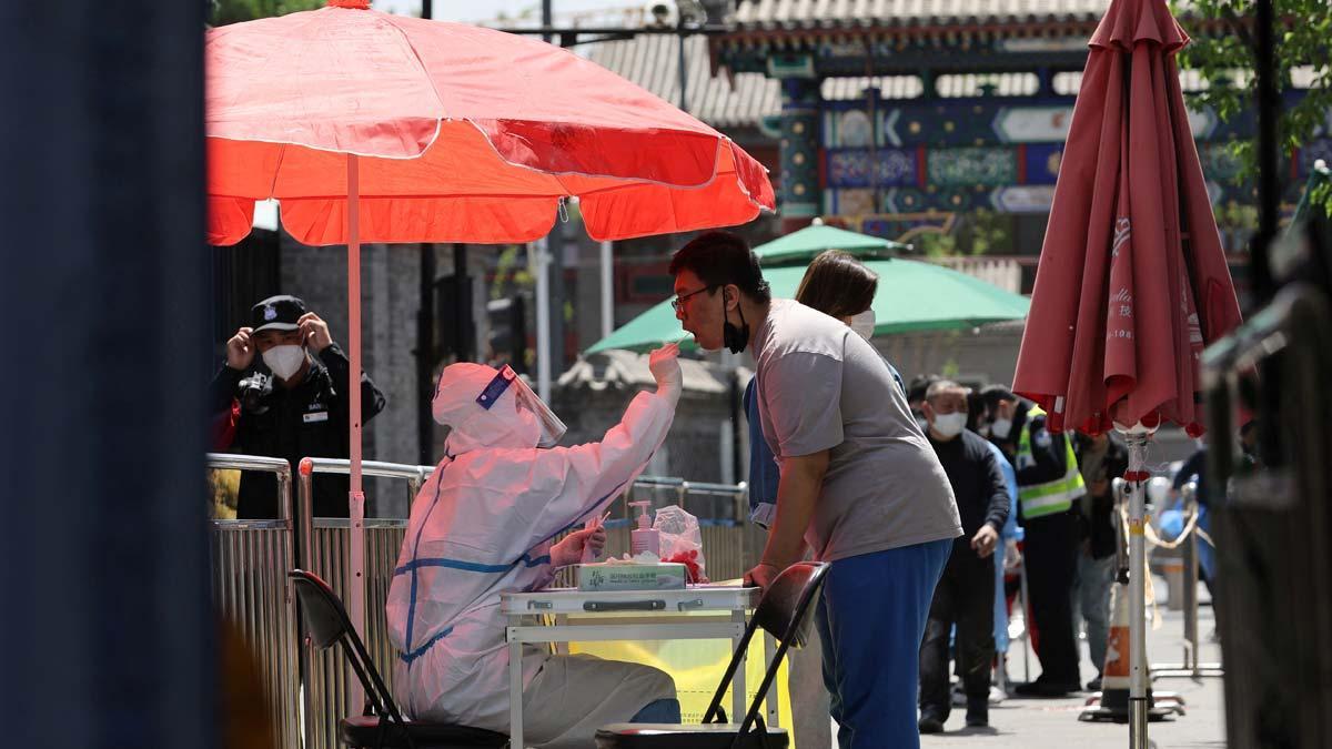 Un sanitario toma una muestra de una prueba de coronavirus en una carpa instalada en Pekín.