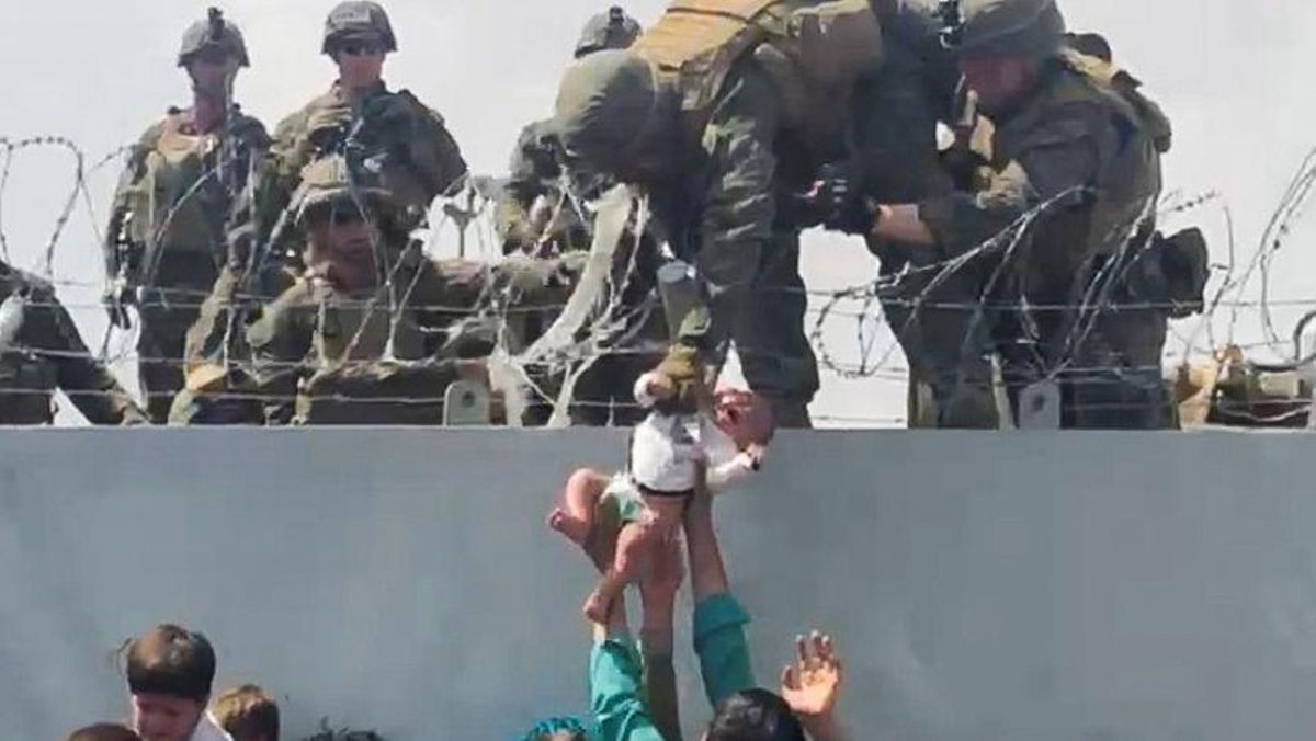 Un bebé es entregado al ejército estadounidense sobre el muro perimetral del aeropuerto para que sea evacuado, en Kabul. Un bebé es entregado al ejército estadounidense sobre el muro perimetral del aeropuerto para que sea evacuado, en Kabul.