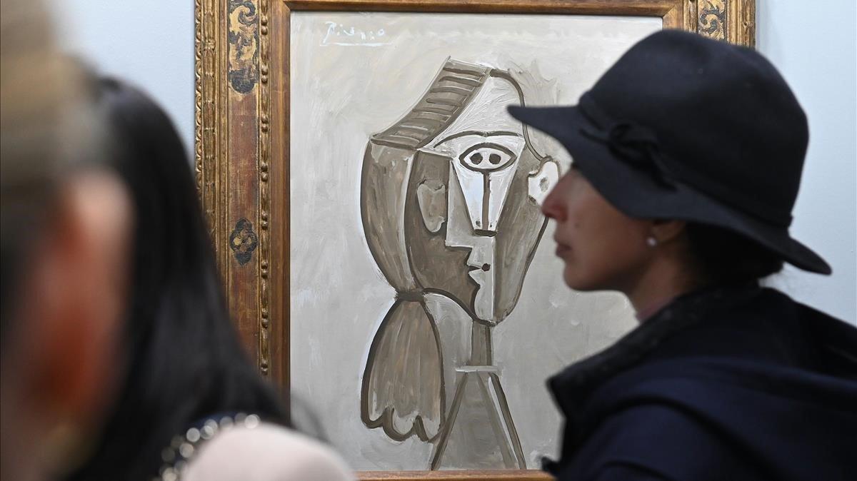 Varios visitantes conversan delante de la obra Retrato de Jaqueline de Pablo Ruiz Picasso.