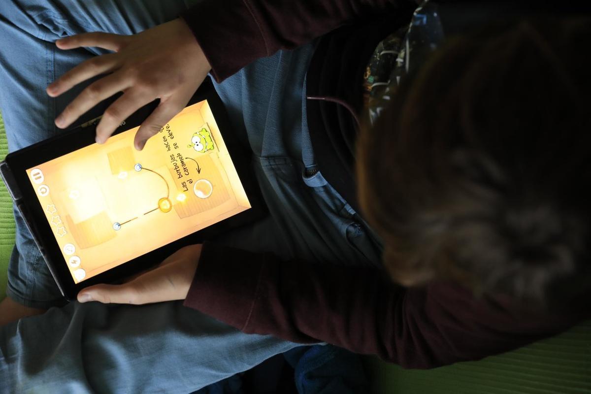Un niño juega con una tableta digital.