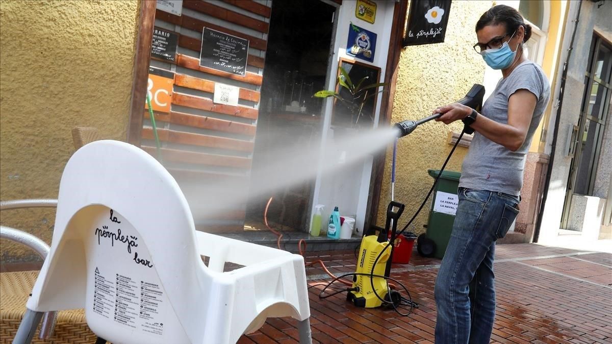 La propietaria de un bar desinfecta con agua y lejía una trona en Las Palmas. La propietaria de un bar desinfecta con agua y lejía una trona en Las Palmas.