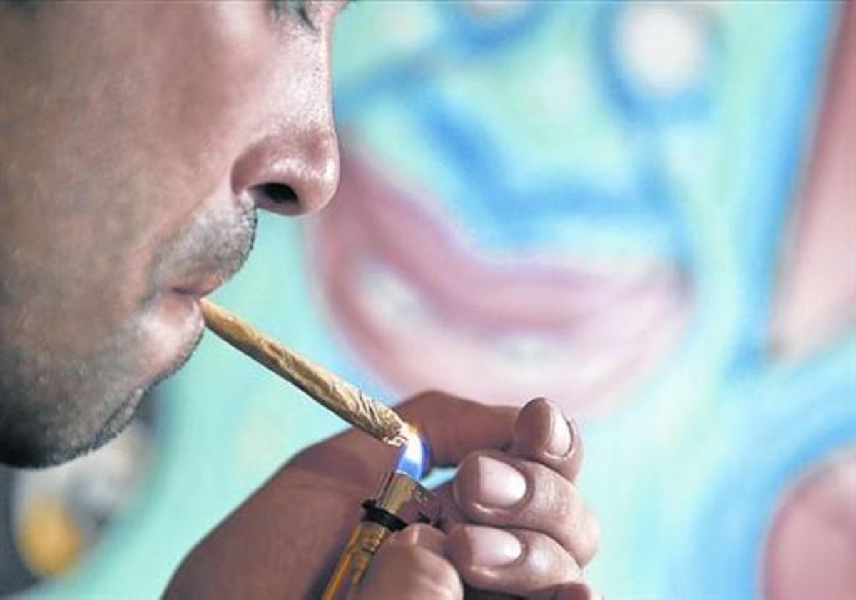 Un socio de un club cannábico de Barcelona se enciende un porro. Un socio de un club cannábico de Barcelona se enciende un porro.