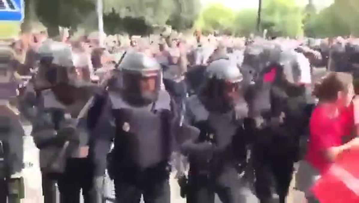 La Policia Nacional carga contra un cordón de seguridad realizado por efectivos del cuerpo de Bombers de la Generalitat frente a un colegio electoral.
