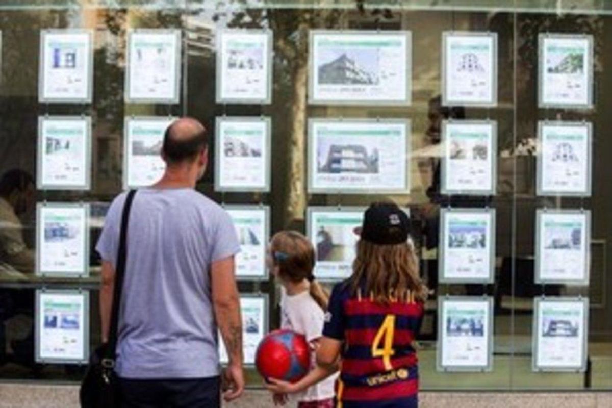 Una família, davant d’una oficina immobiliària. Una família, davant d’una oficina immobiliària.