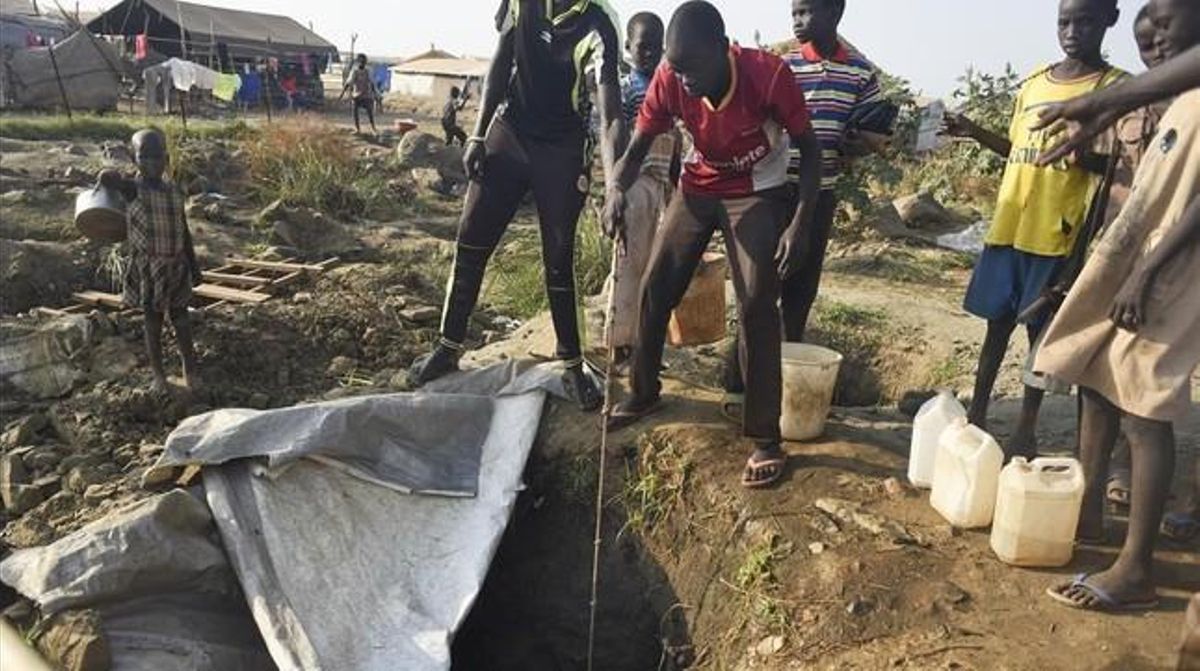 Desplazados por el conflicto civil sacan agua de un pozo en un campo de refugiados de Juba. Desplazados por el conflicto civil sacan agua de un pozo en un campo de refugiados de Juba.