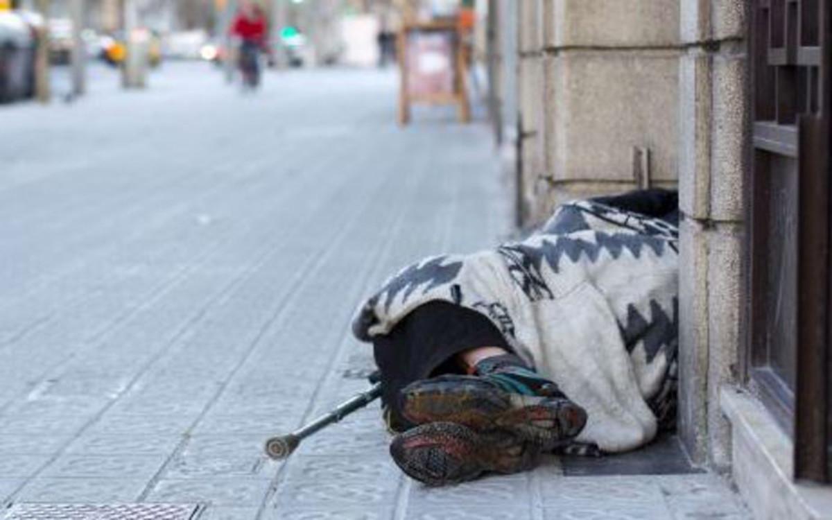 Una persona sin hogar duerme en una calle de la capital catalana. 