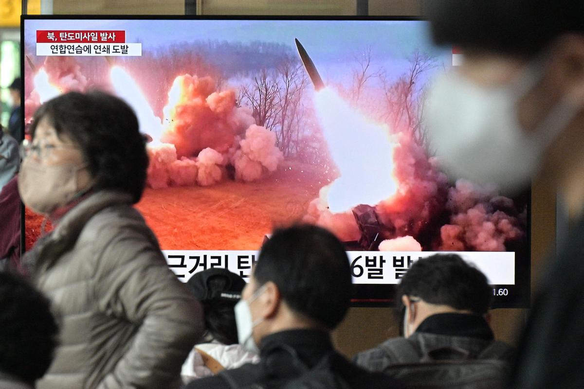 Pasajeros en una estación de Seúl pasan por delante de una televisión que emite imágenes del misil lanzado por Corea del Norte.