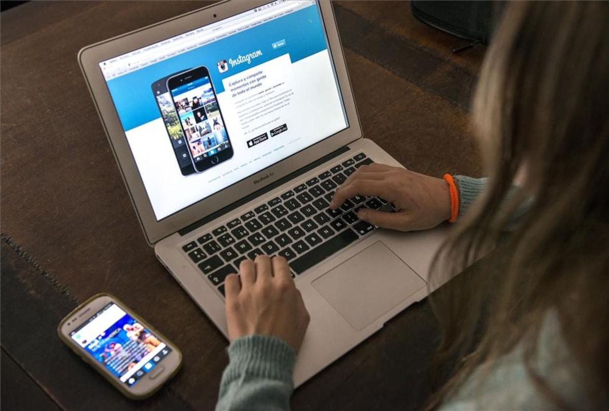 Una joven consulta la web de Instagram. Una joven consulta la web de Instagram.
