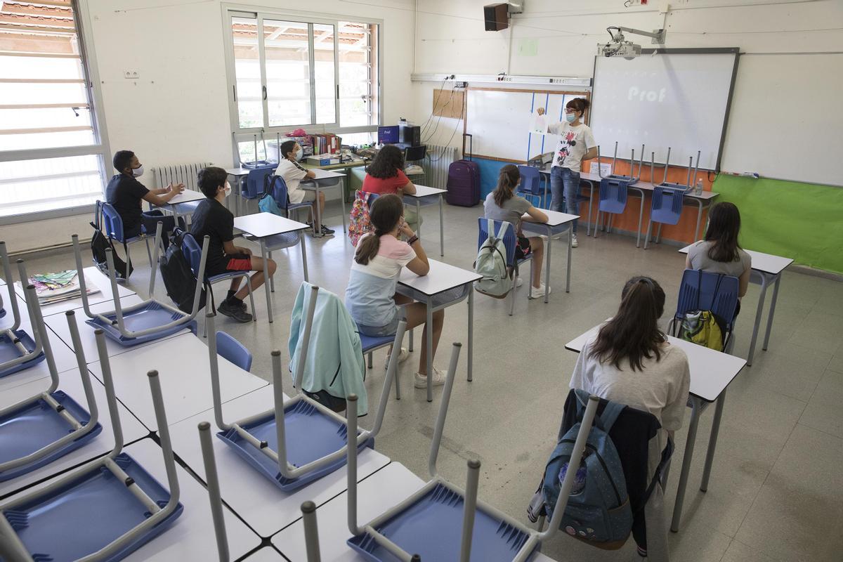 Alumnos y maestros con distancias y mascarillas en la reapertura de los centros escolares tras el confinamiento total, en 2020.