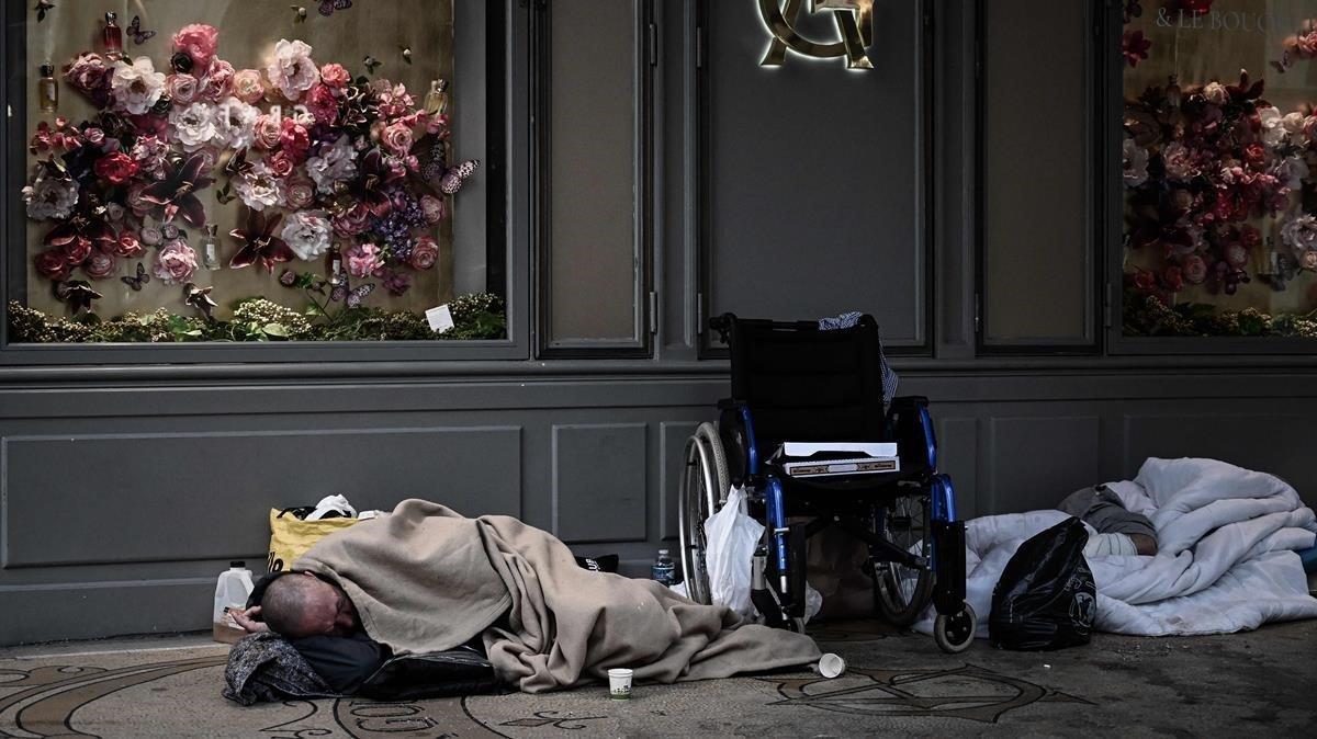 Una persona sin hogar duerme delante de una tienda en París, el pasado abril.