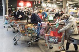 Ciudadanos hacen la compra con mascarillas en Viena.