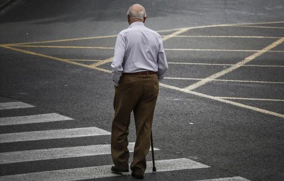 Un pensionista atraviesa una calle. Un pensionista atraviesa una calle.