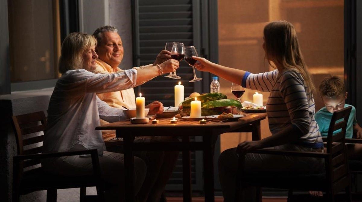 Una familia brinda mientras cena. Una familia brinda mientras cena.