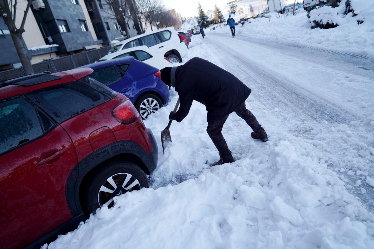 Una persona quita nieve para poder sacar el coche e ir a trabajar. Una persona quita nieve para poder sacar el coche e ir a trabajar.