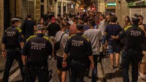 Agentes de la Guàrdia Urbana de Barcelona dispersan las aglomeraciones producidas durante las fiestas de Gràcia