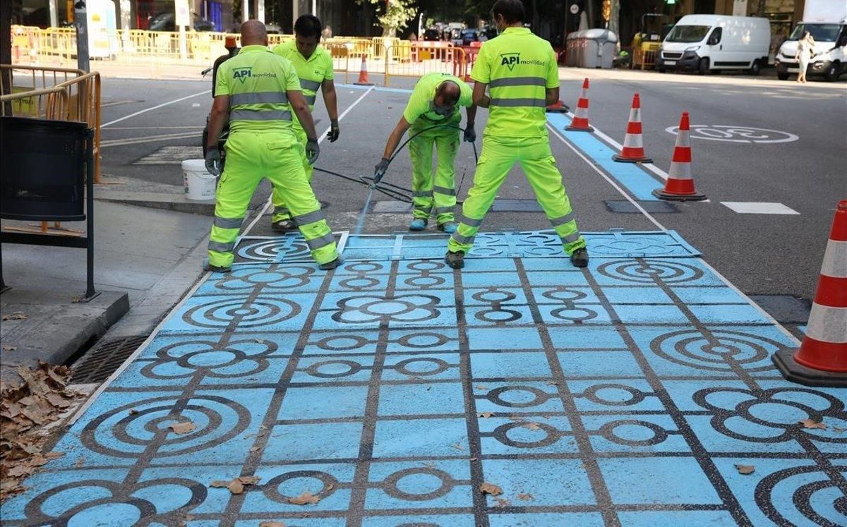 Operarios trabajan pintando en la calle de Rocafort. Operarios trabajan pintando en la calle de Rocafort.