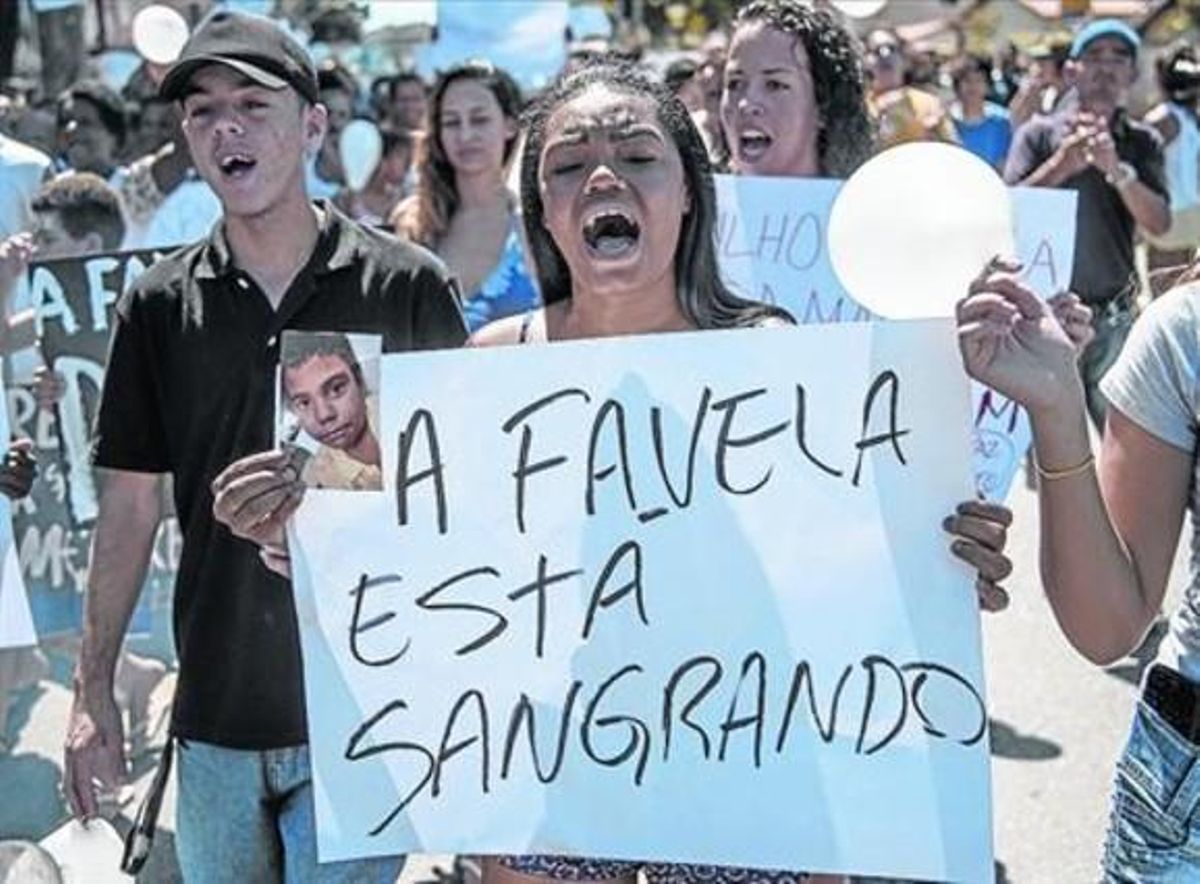 Una dona participa en la ’marxa per la pau’ a la favela Alemao després de la mort d’un nen per la policia. Una dona participa en la ’marxa per la pau’ a la favela Alemao després de la mort d’un nen per la policia.