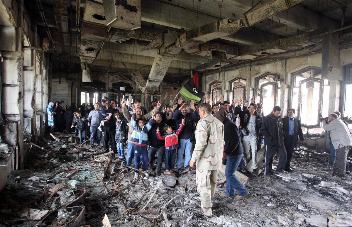 Antigua casa del general Gadafi en Bengasi, convertida en ruinas y en centro de atracción turística para los habitantes de la ciudad  En la foto, manifestación espontánea dentro de las ruinas de la casa.