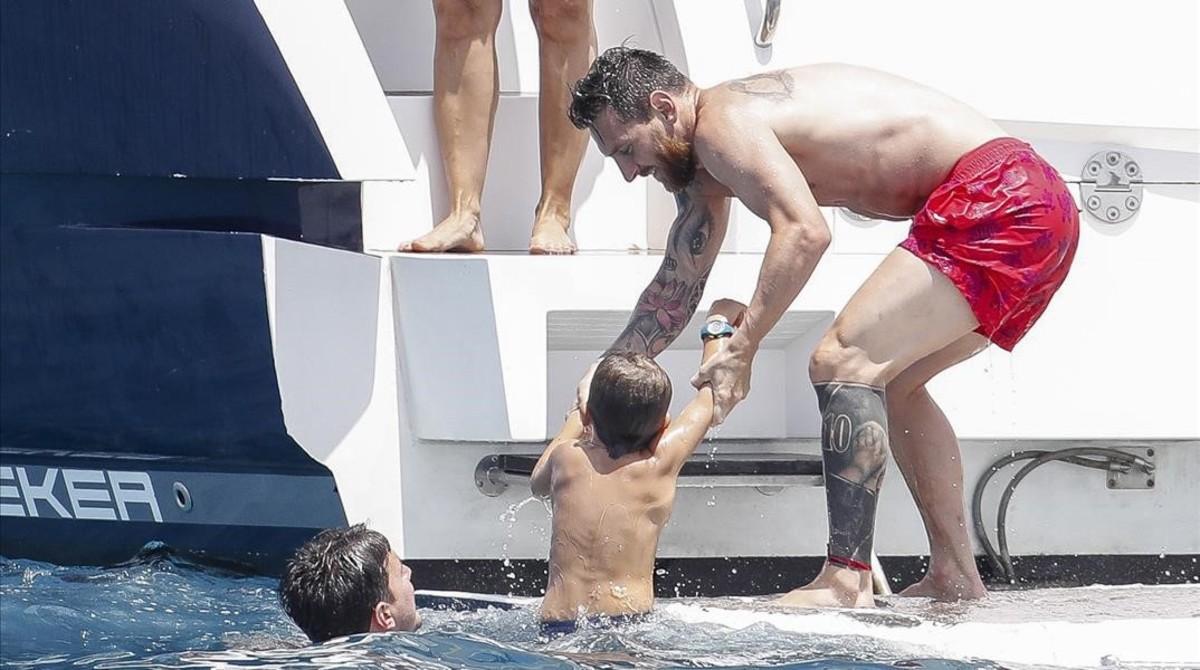Messi ayuda a subir al yate a uno de los niños, este martes en aguas de Eivissa.