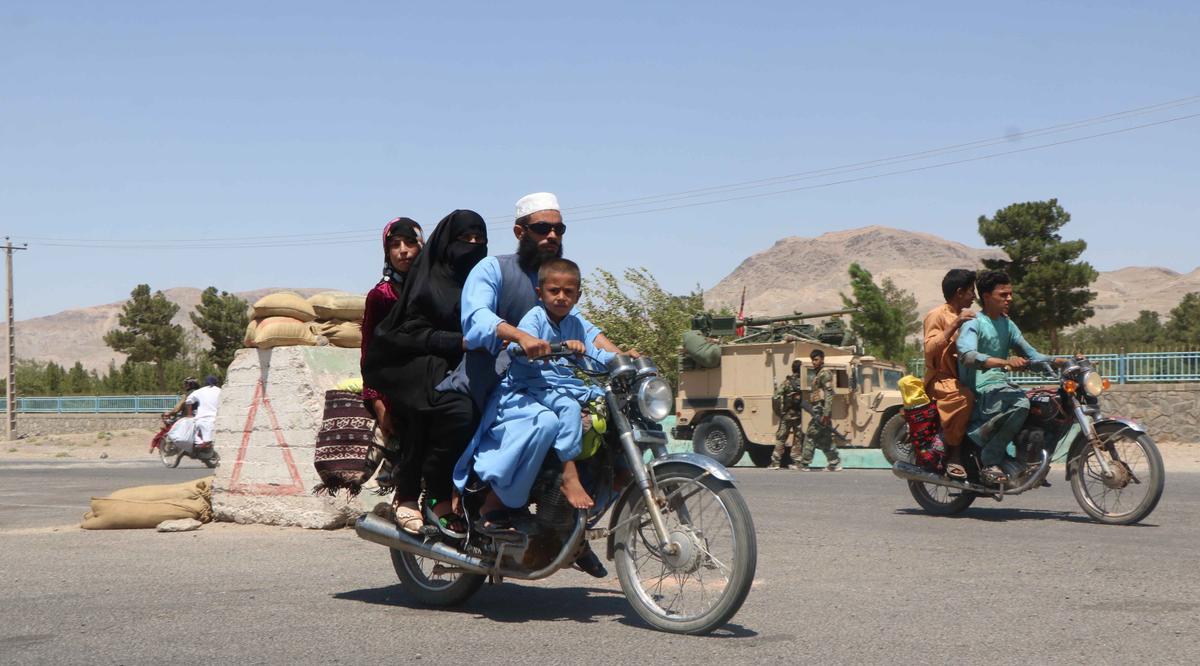 Una familia afgana pasa fente a las fuerzas de seguridad en una de las entradas de Herat.  