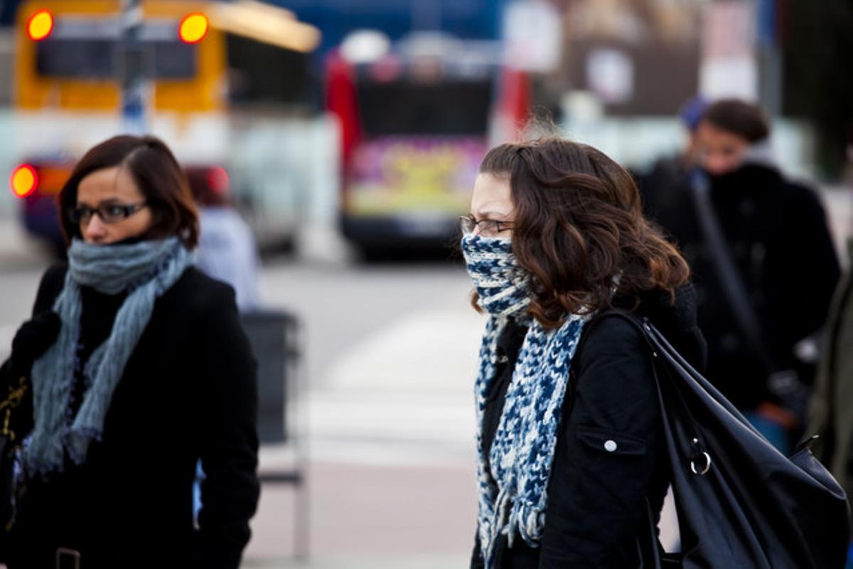 Dos mujeres se protegen del frío, en enero del año pasado junto a la estación de Sants de Barcelona.