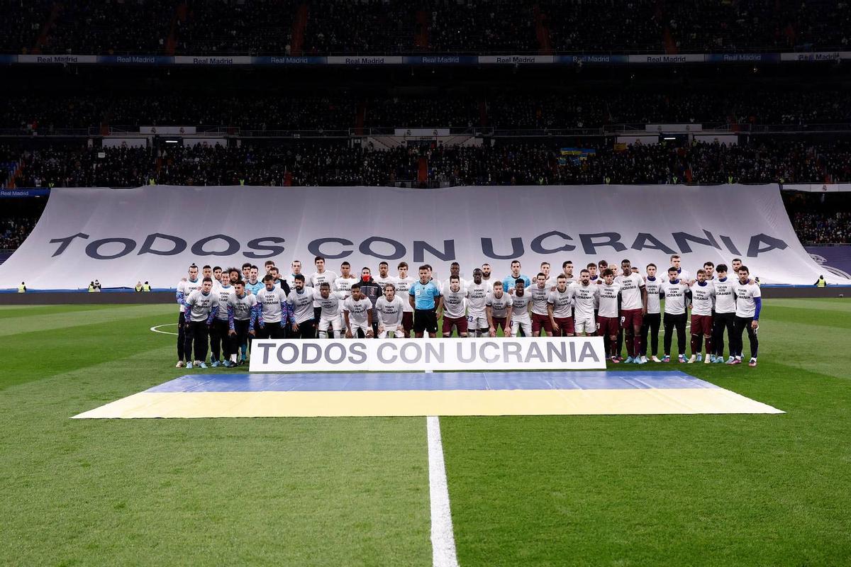 Jugadores del Real Madrid posan con la pancarta en apoyo a Ucrania, tras la invasión rusa.