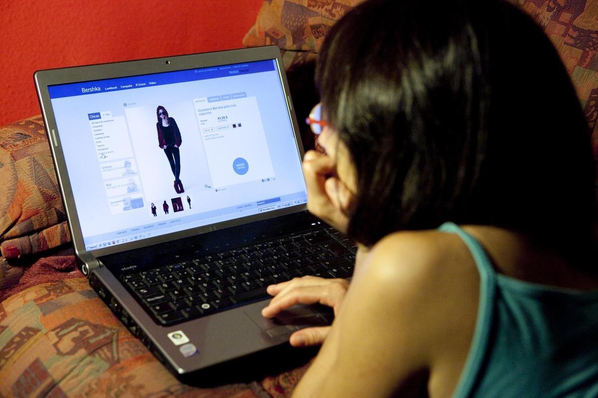 Una joven navega por una página web de ventas ’on line’.