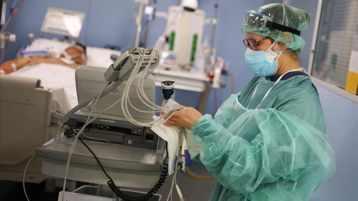 Un miembro del personal del hospital se prepara para tratar a un paciente de covid, en la Unidad de Cuidados Intensivos del Hospital de Sant Pau. Un miembro del personal del hospital se prepara para tratar a un paciente de covid, en la Unidad de Cuidados Intensivos del Hospital de Sant Pau.