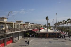 Dos personas pasean en manga corta por el Port Olímpic, el pasado día 21.