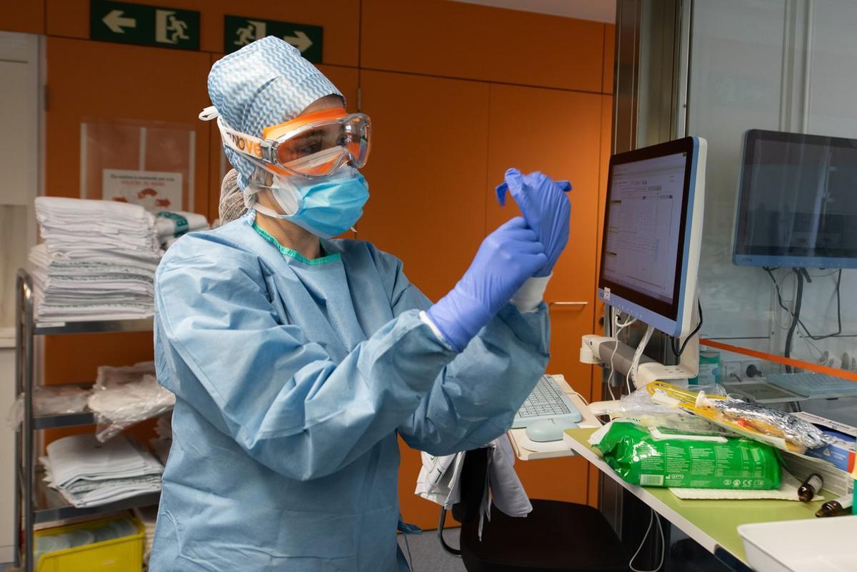 Personal sanitario del Hospital Clínic se preotege con guantes, mascarilla, gafas, bata y gorro.