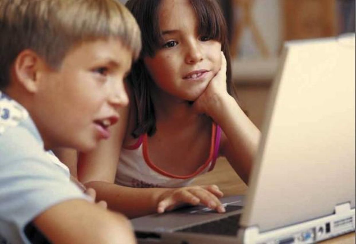 Niños navegando por internet ante un portátil. Niños navegando por internet ante un portátil.