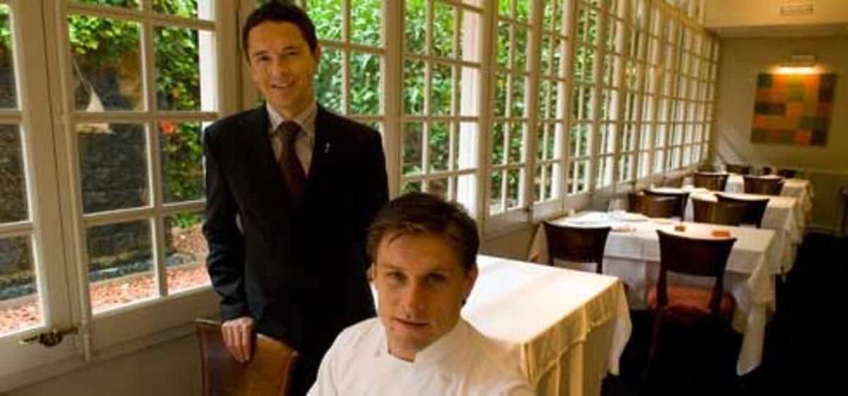 Joan Junyent (de pie) con el chef Carlos Alconchel, en las mesas del Windsor que dan al jardín. Foto: JOAN PUIG Joan Junyent (de pie) con el chef Carlos Alconchel, en las mesas del Windsor que dan al jardín. Foto: JOAN PUIG