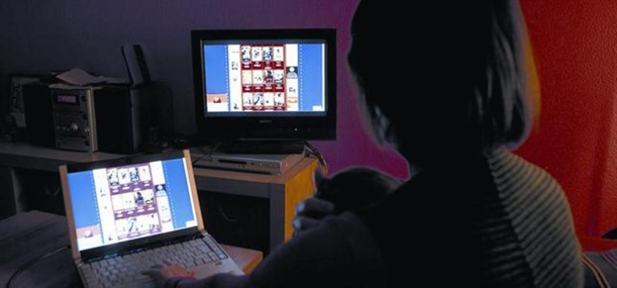 Una mujer descarga una película en su ordenador.
