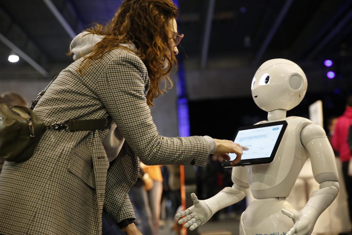 Una asistente al 4YFN interactúa con el robot que ha traído Mediktor.