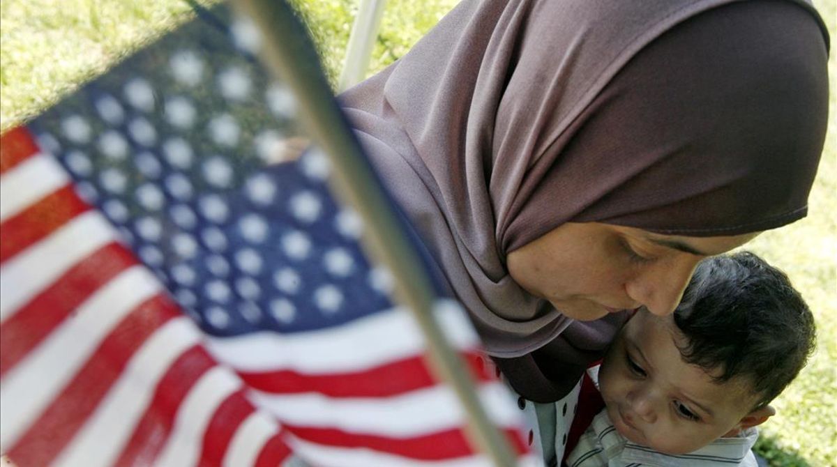 Una mujer marroquí sostiene una bandera de EEUU. Una mujer marroquí sostiene una bandera de EEUU.