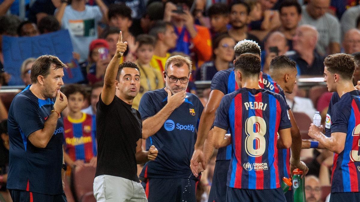 Xavi, escoltado por sus ayudantes Sergio Alegre (izquierda) y Òscar Hernández (derecha) da instrucciones a sus jugadores en el Barça-Rayo.