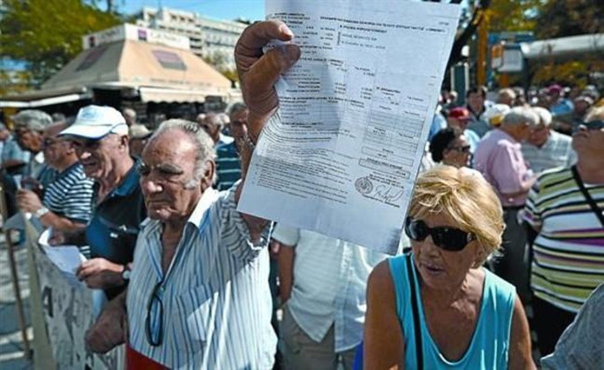 Un pensionista griego muestra el recibo de un impuesto durante una manifestación ante el Ministerio de Finanzas en Atenas. Un pensionista griego muestra el recibo de un impuesto durante una manifestación ante el Ministerio de Finanzas en Atenas.
