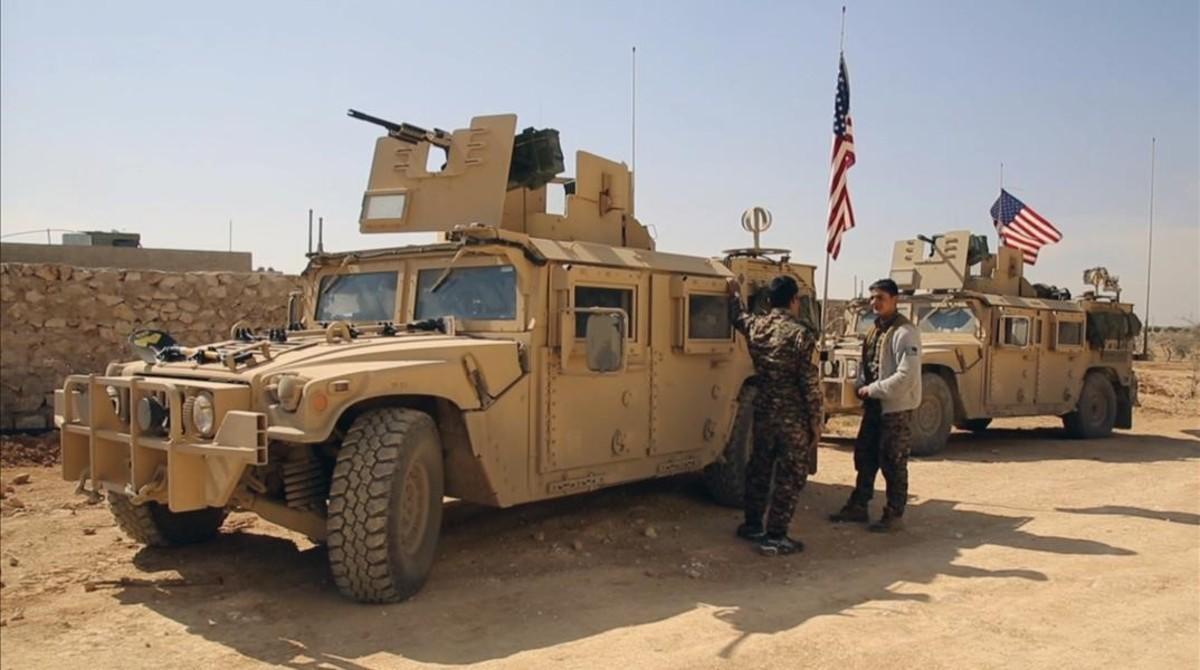Combatientes de las Fuerzas Democráticas Sirias junto a vehículos militares de EEUU en las afueras de Manbij, en la provincia de Alepo, el 7 de marzo.