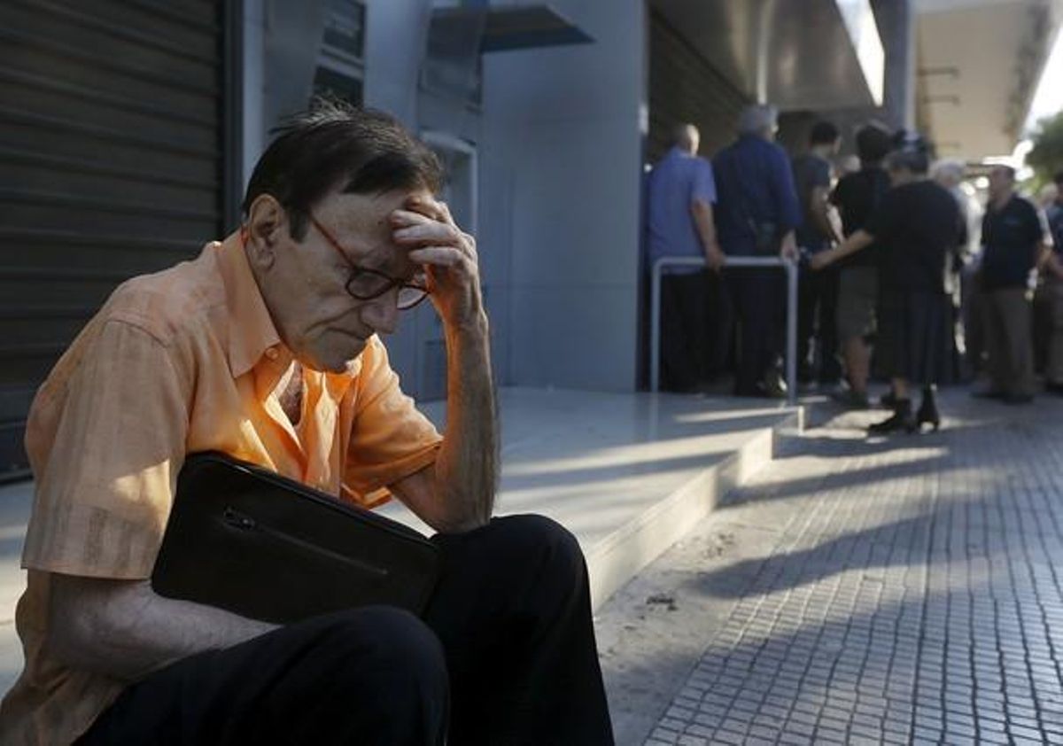 Giorgos, un pensionista de 77 años de Atenas, espera fuera del Banco Nacional de Grecia. Giorgos, un pensionista de 77 años de Atenas, espera fuera del Banco Nacional de Grecia.