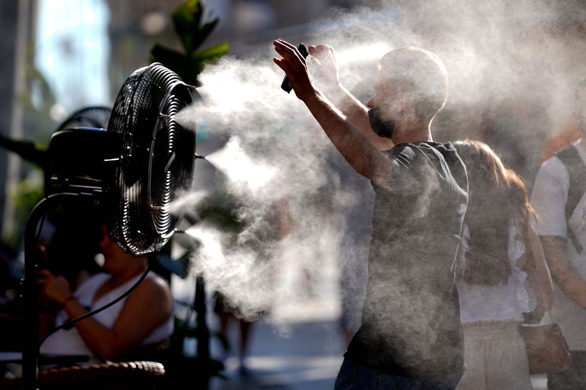 Peatones de la Gran Vía se refrescan a causa del calor con un ventilador que expulsa agua . IMAGEN David Castro Peatones de la Gran Vía se refrescan a causa del calor con un ventilador que expulsa agua . IMAGEN David Castro