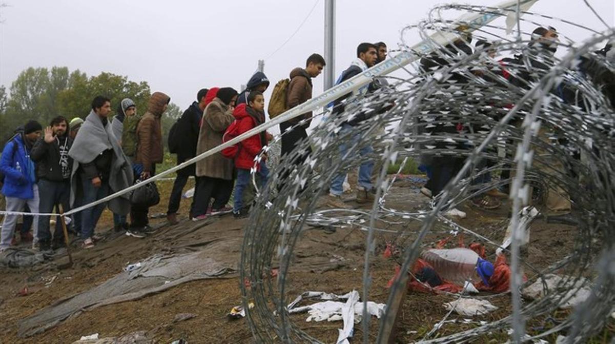 Refugiados cruzando la frontera entre Hungría y Croacia después de llegar en tren a la ciudad croata de Botovo.